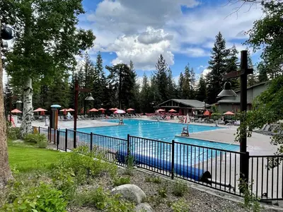 a large swimming pool with a blue fence at Bitter Brush by Tahoe Getaways -4 BR Pet Friendly, Northstar Home with Hot Tub, Pool Table, & Ski Shuttle in Truckee