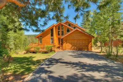 a log cabin with a driveway in front of it at Bitter Brush by Tahoe Getaways -4 BR Pet Friendly, Northstar Home with Hot Tub, Pool Table, & Ski Shuttle in Truckee