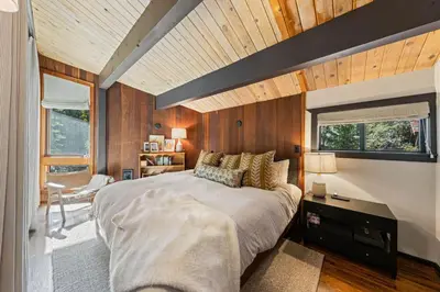 a bedroom with a large bed and wooden walls at Birchwood Retreat by Tahoe Getaways - Newly Remodeled Pet Friendly Home in Alpine Meadows with Wood Fireplace, Hot Tub & Ski Shuttle! in Alpine Meadows