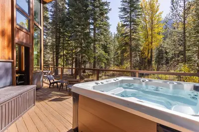a jacuzzi tub on the deck of a house at Birchwood Retreat by Tahoe Getaways - Newly Remodeled Pet Friendly Home in Alpine Meadows with Wood Fireplace, Hot Tub & Ski Shuttle! in Alpine Meadows