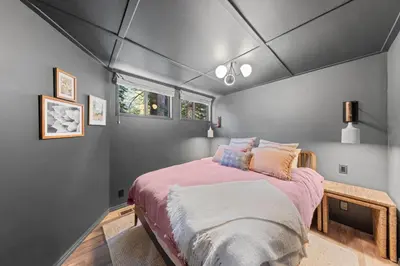 a bedroom with a large bed with pink sheets at Birchwood Retreat by Tahoe Getaways - Newly Remodeled Pet Friendly Home in Alpine Meadows with Wood Fireplace, Hot Tub & Ski Shuttle! in Alpine Meadows