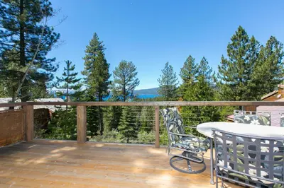 a patio with a table and chairs on a deck at Beaver Lake View by Tahoe Getaways - Pet Friendly 3 BR with Hot Tub, Wood Fireplace & Close to Skiing in Kings Beach