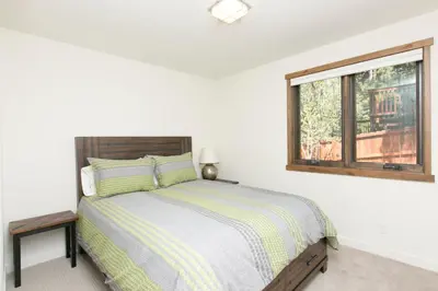a white bedroom with a bed and a window at Beaver Lake View by Tahoe Getaways - Pet Friendly 3 BR with Hot Tub, Wood Fireplace & Close to Skiing in Kings Beach