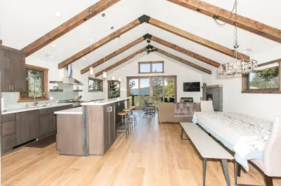 a kitchen and living room with a large bed in a room at Beaver Lake View by Tahoe Getaways - Pet Friendly 3 BR with Hot Tub, Wood Fireplace & Close to Skiing in Kings Beach