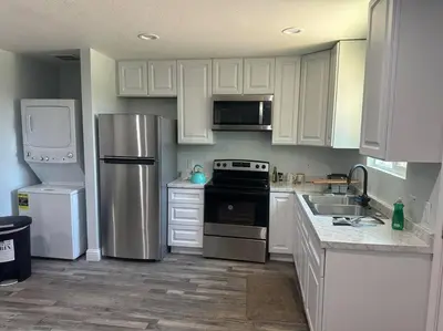 a kitchen with white cabinets and stainless steel appliances at Guest house near UCD Med. Center in Sacramento