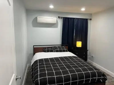 a bedroom with a black and white bed and a window at Guest house near UCD Med. Center in Sacramento