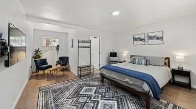 a white bedroom with a bed and a rug at Adventure Lodge in South Lake Tahoe
