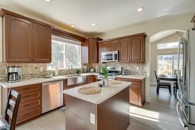 a large kitchen with wooden cabinets and a kitchen island at 4 Mi to Downtown Reno Family Retreat with Fireplace in Reno