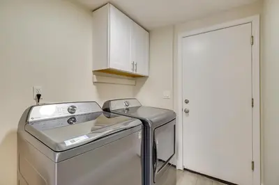 a kitchen with a washer and dryer next to a door at 4 Mi to Downtown Reno Family Retreat with Fireplace in Reno