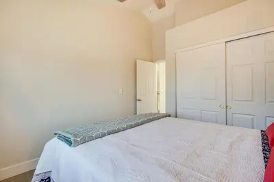 a bedroom with a large white bed with a door at 4 Mi to Downtown Reno Family Retreat with Fireplace in Reno