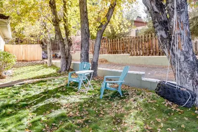 two chairs and a table in a yard with trees at Spacious Reno Vacation Rental about 3 Mi to MidTown! in Reno