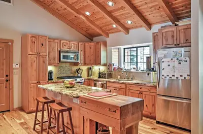 a kitchen with wooden cabinets and a island with bar stools at Truckee Northstar Family Home by Jaeger Retreat in Truckee