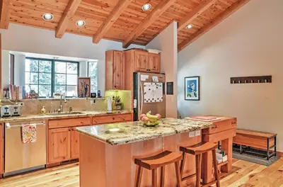 a kitchen with wooden cabinets and a kitchen island with bar stools at Truckee Northstar Family Home by Jaeger Retreat in Truckee