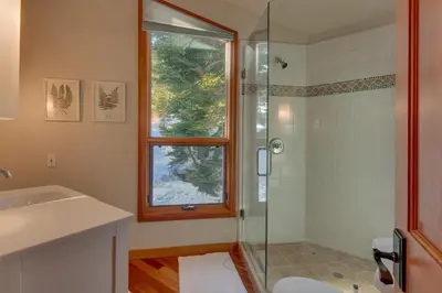a bathroom with a shower and a sink and a window at Big John at Alpine Meadows by Tahoe Getaways - Mountain Views, Cozy Fireplace, Shuttle to Slopes! in Alpine Meadows