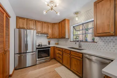 a kitchen with wooden cabinets and stainless steel appliances at Camp Telemark by Tahoe Getaways - Pet-Friendly 3 BR in Tahoe Donner with Hot Tub & Wood Fireplace in Truckee