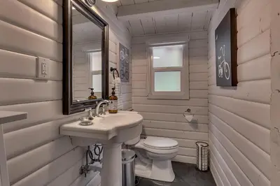 a white bathroom with a sink and a toilet at Blackwood Bungalow on the West Shore by Tahoe Getaways - 3 BR Pet Friendly & Walking Distance to the Lake in Homewood