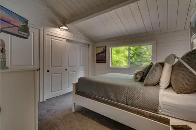 a bedroom with a bed and a window at Blackwood Bungalow on the West Shore by Tahoe Getaways - 3 BR Pet Friendly & Walking Distance to the Lake in Homewood