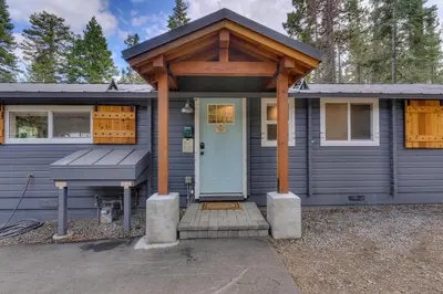 a blue house with a porch and a white door at Blackwood Bungalow on the West Shore by Tahoe Getaways - 3 BR Pet Friendly & Walking Distance to the Lake in Homewood