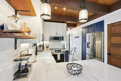 a kitchen with white counter tops and blue cabinets at Cobalt Cabin by Tahoe Getaways - Beautifully Remodeled Pet Friendly 3 BR with Hot Tub & EV in Carnelian Bay