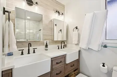 a white bathroom with a sink and a mirror at Cobalt Cabin by Tahoe Getaways - Beautifully Remodeled Pet Friendly 3 BR with Hot Tub & EV in Carnelian Bay