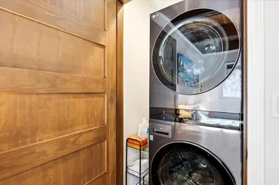 a washer and dryer in a room next to a door at Cobalt Cabin by Tahoe Getaways - Beautifully Remodeled Pet Friendly 3 BR with Hot Tub & EV in Carnelian Bay