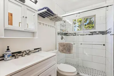 a white bathroom with a sink and a toilet at Cedar Chalet by Tahoe Getaways - Stunning 3BR with Fireplace & Pet Friendly in Tahoe Vista