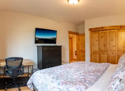 a bedroom with a bed and a desk and a television at Coyote Run Retreat by Tahoe Getaways - 3BR Pet Friendly with HOA Amenities, Minutes to Downtown Truckee & Northstar Resort! in Truckee