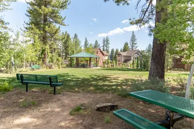 a park with two green benches and a gazebo at Coyote Run Retreat by Tahoe Getaways - 3BR Pet Friendly with HOA Amenities, Minutes to Downtown Truckee & Northstar Resort! in Truckee