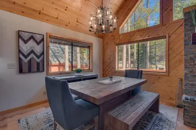 a dining room with a wooden table and chairs at Cottonwood by Tahoe Getaways - 3BR Tahoe Donner with 2 Bonus Rooms, Hot Tub, Fireplace, Ping Pong & HOA Amenities in Truckee