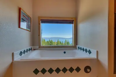 a large bath tub in a bathroom with a window at Crystal Lakeview Lodge by Tahoe Getaways - Private Hot Tub, Foosball Table & Tahoe Park HOA in Tahoe City