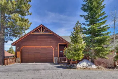 a house with a garage and a tree at Crystal Lakeview Lodge by Tahoe Getaways - Private Hot Tub, Foosball Table & Tahoe Park HOA in Tahoe City
