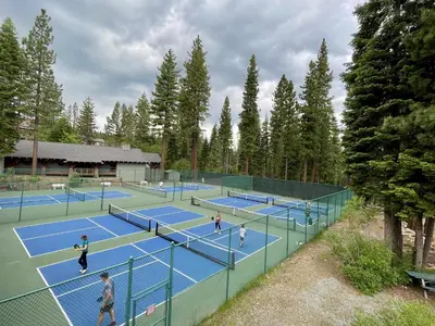a group of people playing tennis on tennis courts at Big Springs by Tahoe Getaways - 6BR w Ski Shuttle, Fireplace & Entertainment Room in Truckee