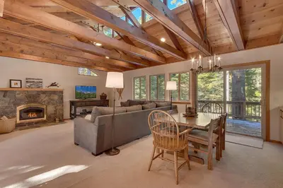 a living room with a couch and a table and a fireplace at Deer Hollow by Tahoe Getaways at Northstar - 4BR w Hot Tub, Ski Shuttle, & HOA Amenities in Truckee