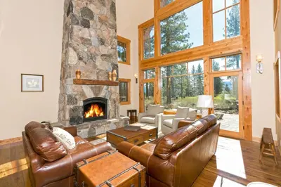 a living room with leather furniture and a stone fireplace at Caleb's Getaway by Tahoe Getaways at Old Greenwood- 3BR w Bonus Room, Pets Welcome & Ski Shuttle! in Truckee