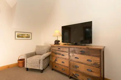 a living room with a dresser with a television on it at Caleb's Getaway by Tahoe Getaways at Old Greenwood- 3BR w Bonus Room, Pets Welcome & Ski Shuttle! in Truckee