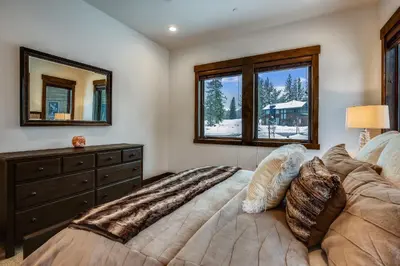 a bedroom with a bed with a dresser and two windows at Allure at Schaffer's Mill by Tahoe Getaways - 4BR Pet-Friendly Home w Private Hot Tub & Air Conditioning! in Truckee