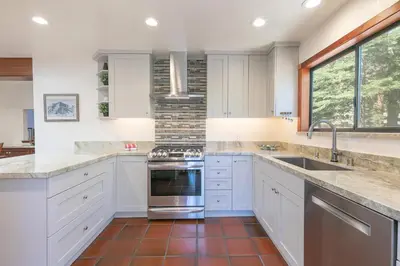 a kitchen with white cabinets and a sink and a stove at Basque Lodge at Northstar by Tahoe Getaways - Pet-Friendly 5BR w Free Shuttle & HOA Amenities in Truckee