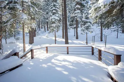 a snow covered park with a fence and trees at Basque Lodge at Northstar by Tahoe Getaways - Pet-Friendly 5BR w Free Shuttle & HOA Amenities in Truckee