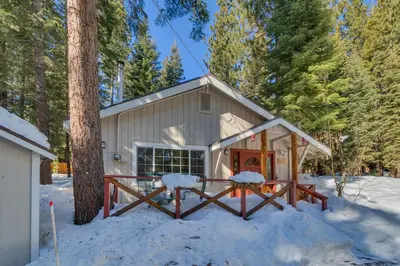 a cabin in the woods in the snow at Glades Getaway by Tahoe Getaways - Charming Pet-Friendly 3 BD North Shore Cabin w Wood Fireplace & Short Drive to Ski Resorts in Carnelian Bay
