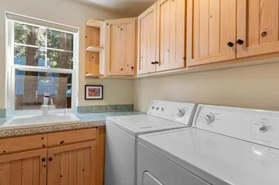 a laundry room with a washer and dryer and a window at Fox Crossing at Tahoe Donner by Tahoe Getaways - 3BR Vacation Rental w Forested Views & HOA Amenities! in Truckee