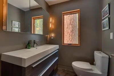 a bathroom with a white sink and a toilet at Mod Haus by Tahoe Getaways - Mountain Modern West Shore Home w Private Beach and Pier, Near Skiing in Homewood