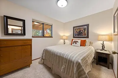 a bedroom with a bed and a dresser and a mirror at Nightingale Retreat by Tahoe Getaways - 3BR, Close to Tahoe City, Walk to Bike Path & Private Beach Access in Tahoe City