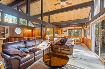 a living room with leather couches and a table at Nightingale Retreat by Tahoe Getaways - 3BR, Close to Tahoe City, Walk to Bike Path & Private Beach Access in Tahoe City