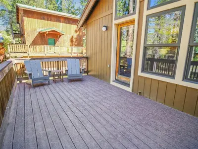 a deck with two chairs and a table on a house at Rustic Retreat by Tahoe Getaways - 4BR Tahoe Donner Contemporary Cabin w Forest Views, Pet-Friendly & HOA Amenities in Truckee
