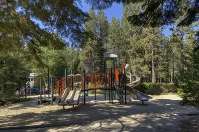 a playground with a slide in a park at Sunlit Pines by Tahoe Getaways - 2BR in Tahoe Park w Hot Tub, Fenced Yard & Pet Friendly! in Tahoe City