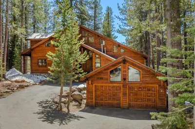 a log home in the woods with a garage at Tree Haus by Tahoe Getaways - Unique Pet-Friendly Tahoe Donner Home w EV & HOA Pool & Beach in Truckee