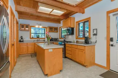 a large kitchen with wooden cabinets and counters at Tree Haus by Tahoe Getaways - Unique Pet-Friendly Tahoe Donner Home w EV & HOA Pool & Beach in Truckee