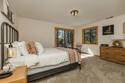 a bedroom with a bed and a dresser and windows at Tree Haus by Tahoe Getaways - Unique Pet-Friendly Tahoe Donner Home w EV & HOA Pool & Beach in Truckee