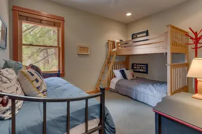 a bedroom with two bunk beds and a ladder at Tranquil Retreat by Tahoe Getaways - 3BR Pet-Friendly Home w Private Hot Tub, Views & HOA Amenities in Truckee