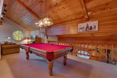 a pool table in a room with wooden ceilings at Dogwood Place by Tahoe Getaways - 3BR Pet-Friendly Tahoe Donner Home w Hot Tub, Pool Table, Wood Fireplace & HOA Amenities in Truckee